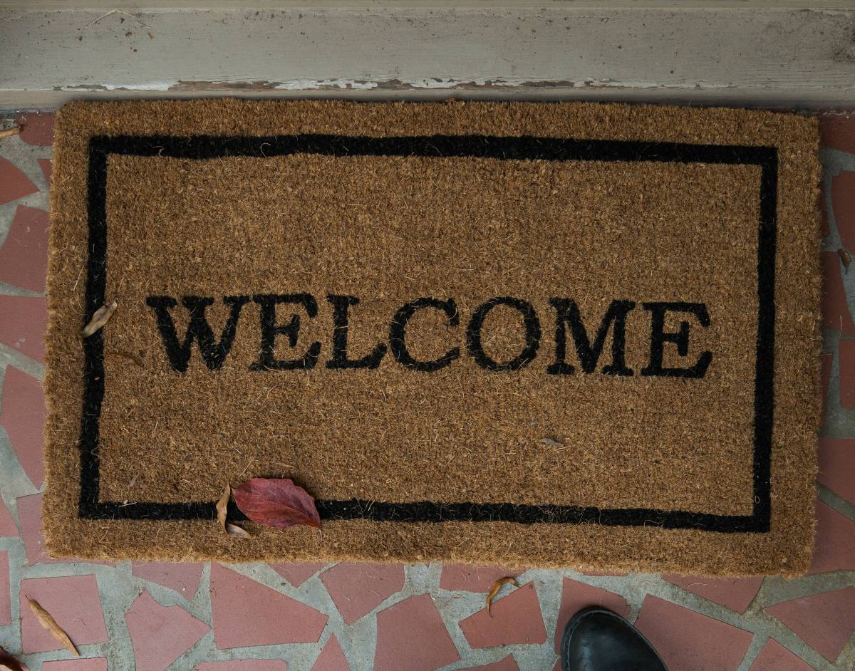 Burlap Welcome mat on pink tile with cream grout